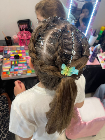 Menina de tranças com presilha colorida feita no camarim da Colors Lazer