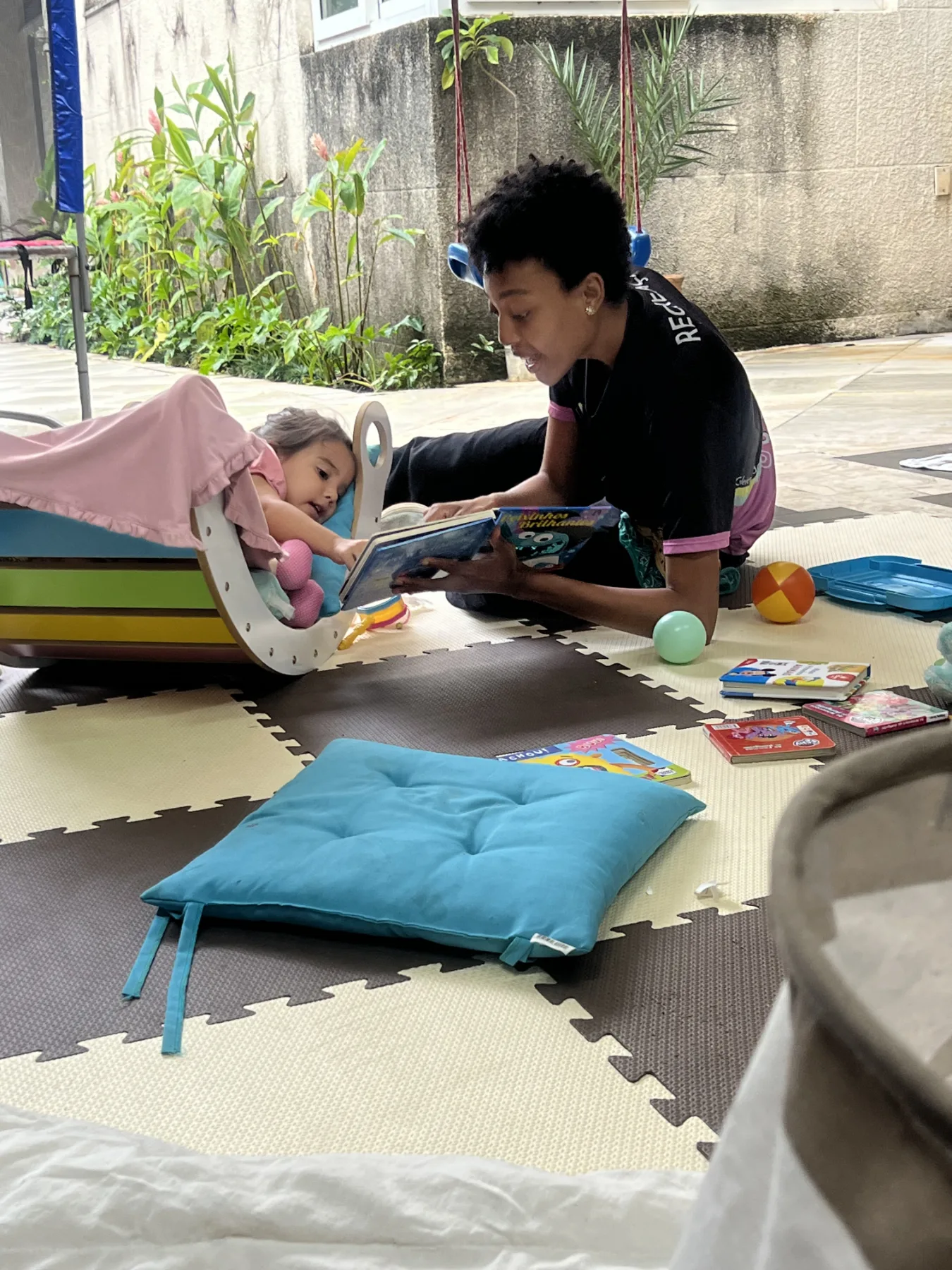 Recreadora da Colors Lazer lendo um livro com um bebê no Espaço Baby