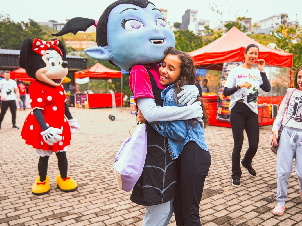 Famílias e personagens juntos em um evento aberto da Colors Lazer