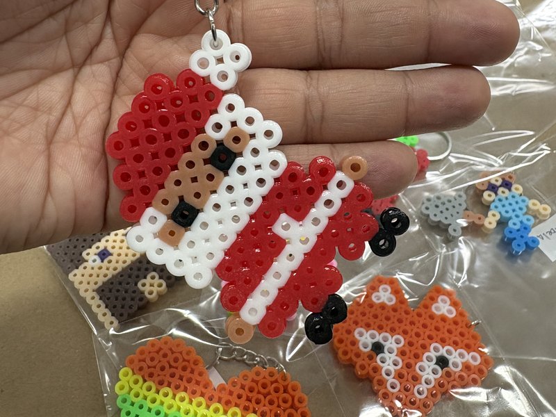 Chaveiros de pixel art montados com miçangas na oficina da Colors Lazer