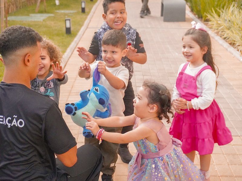 Recreador da Colors Lazer de uniforme brincando com duas crianças