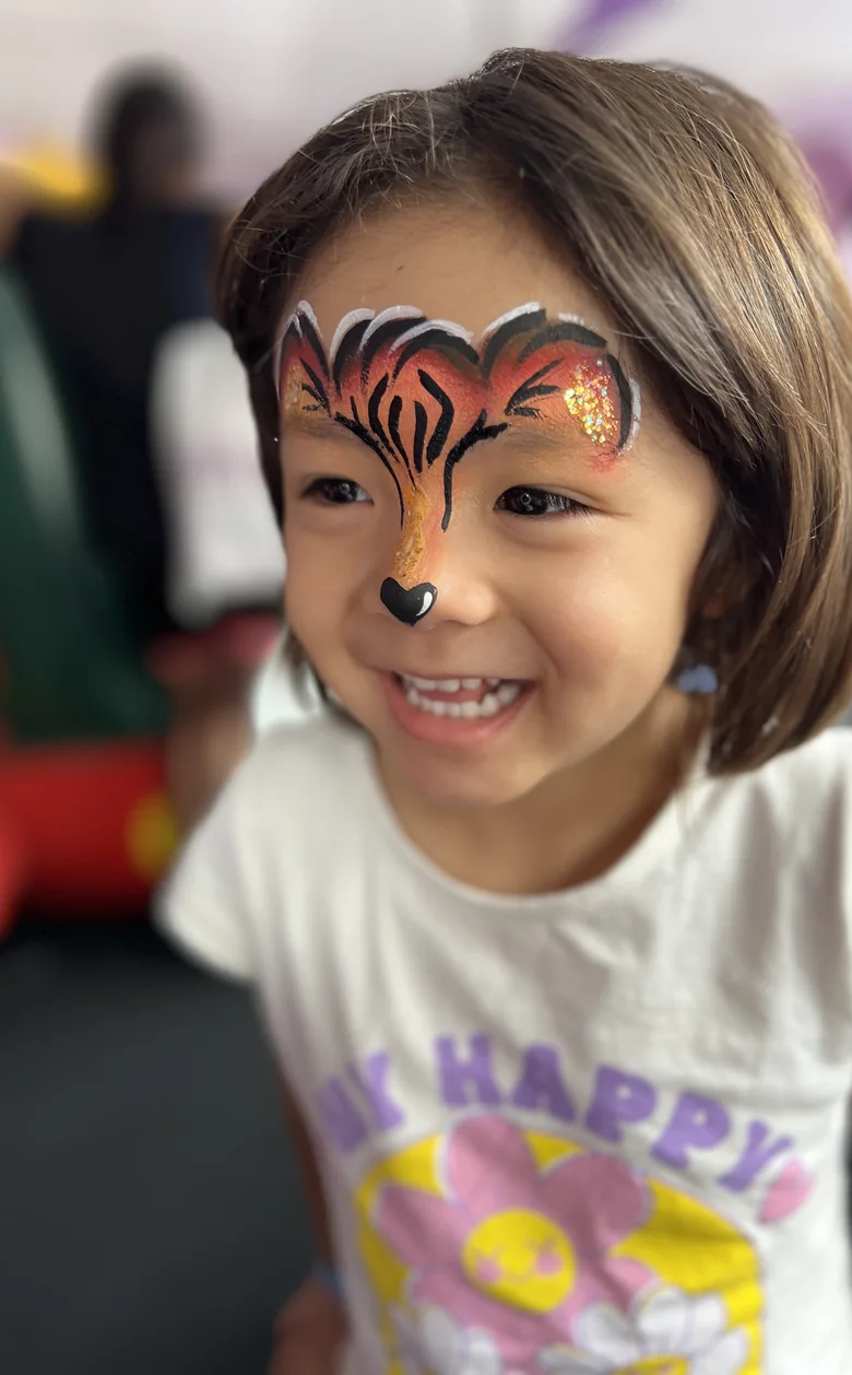 Menina com pintura facial de tigre feita pela equipe da Colors Lazer